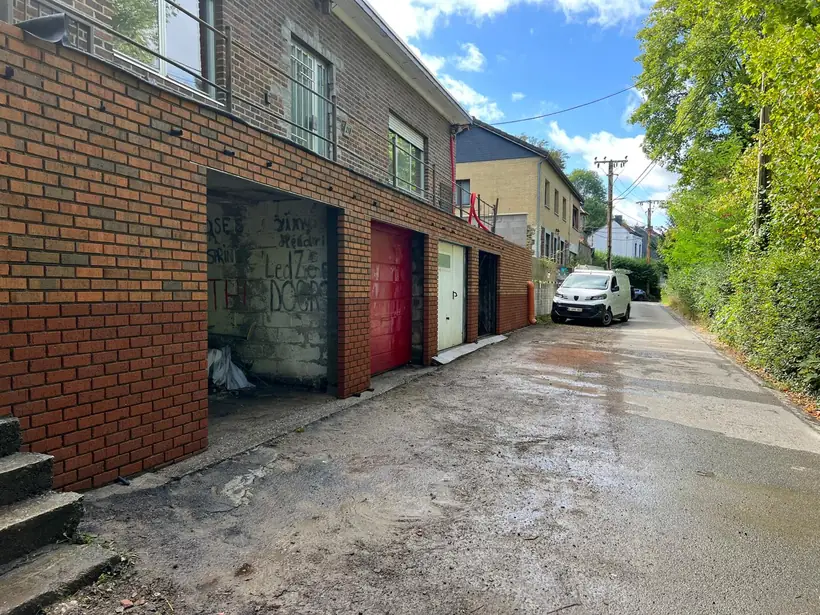 Ruelle bordée d'une façade en brique rouge entièrement remontée, sol remis à niveau